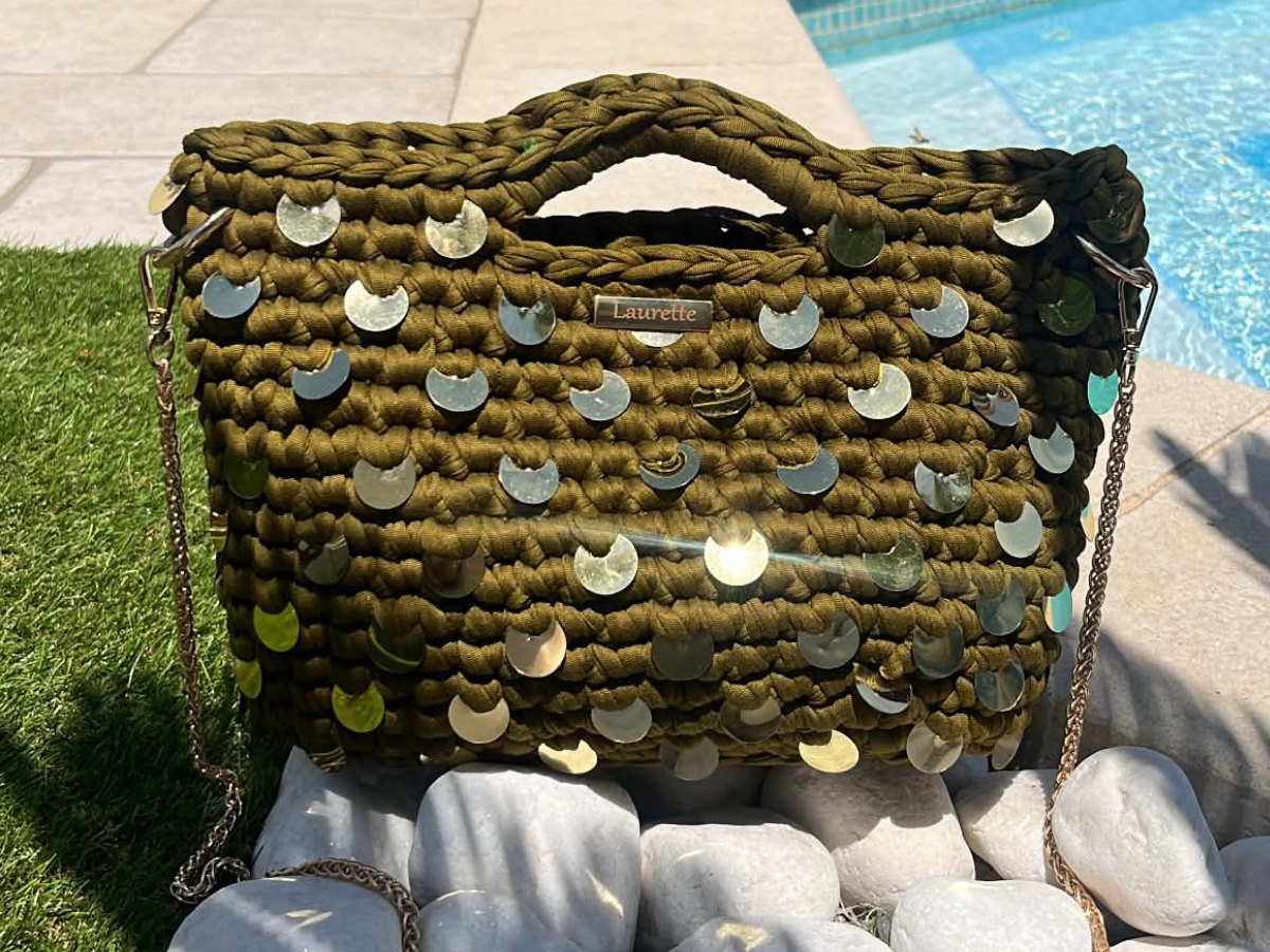 Sac Laurette kaki à sequins dorés Laurette Créations posé sur des galets au soleil